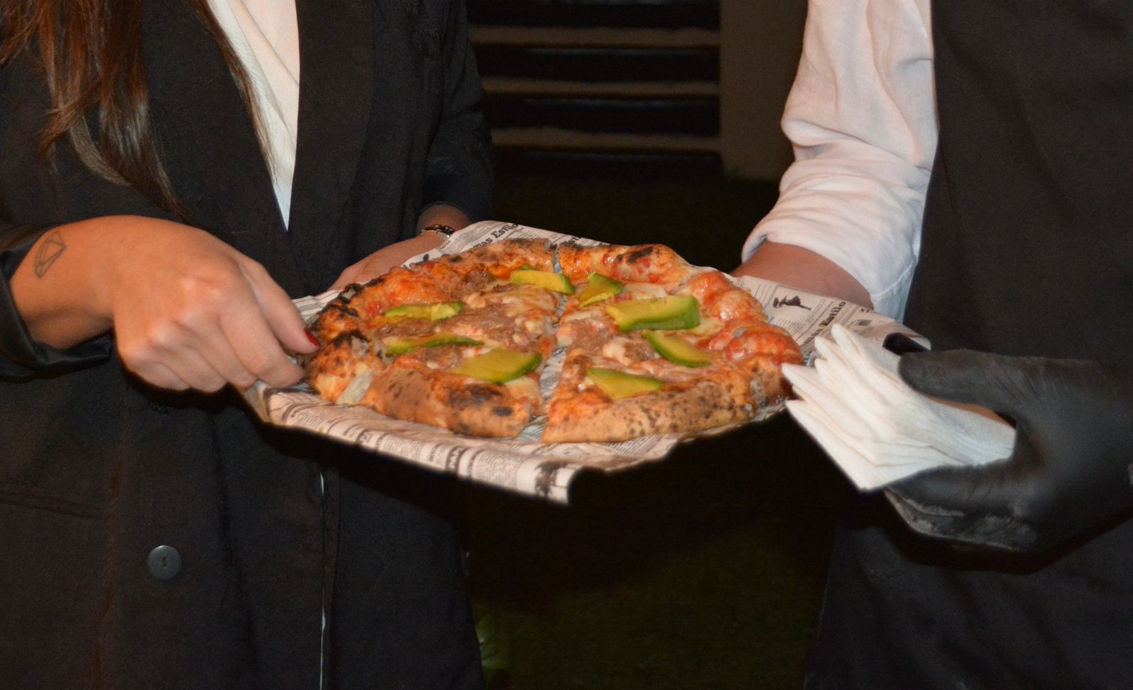 Equipo sirviendo pizza en un evento